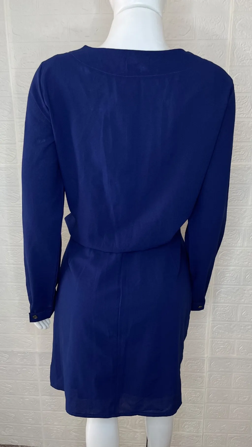 Vestido azul marinho com manga longa, possui decote com amarraçã
